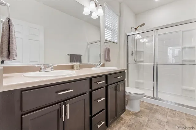 a bathroom with a double vanity sink a toilet and a mirror