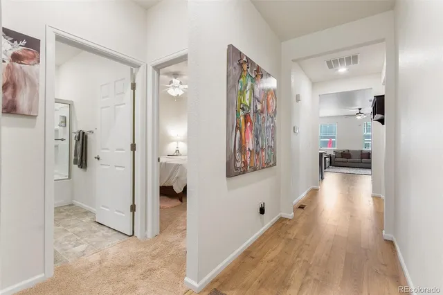 a view of a hallway with shelves and wooden floor