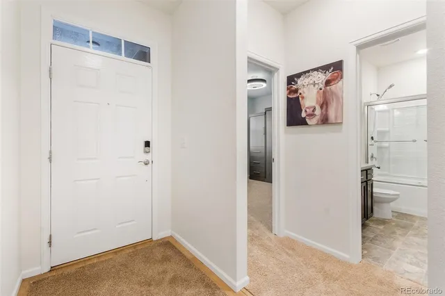 a view of a hallway with closet and bathroom