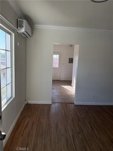 a view of a big room with wooden floor and windows