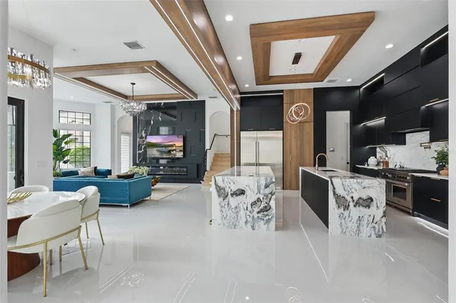 a large kitchen with stainless steel appliances kitchen island granite countertop a sink and wooden cabinets