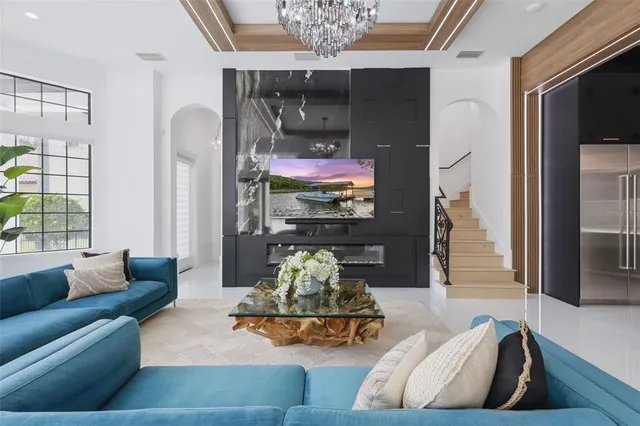 a spacious bedroom with a large bed and a chandelier