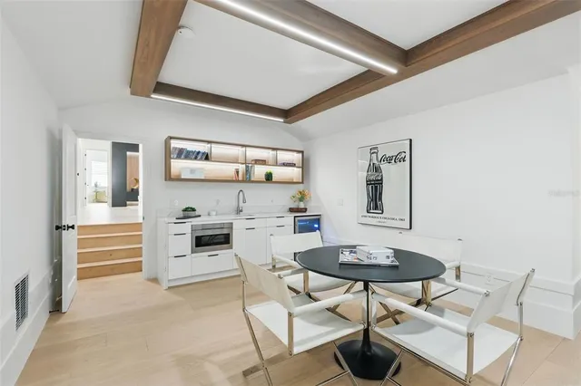 a aerial view of a house with yard and trees in the background