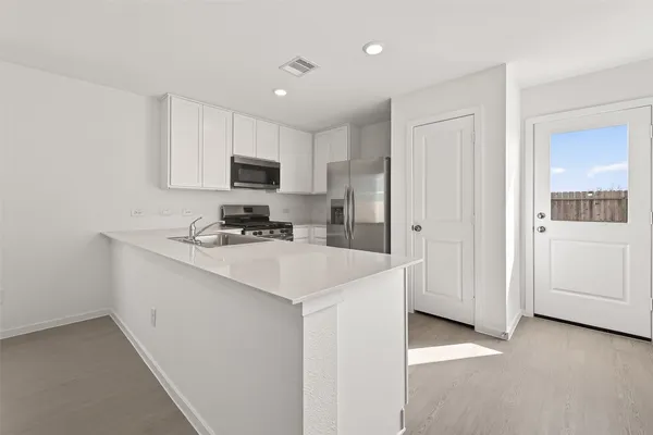 a kitchen with a refrigerator and a stove top oven