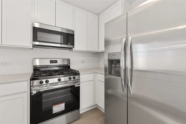 a kitchen with stainless steel appliances white cabinets and a granite counter tops