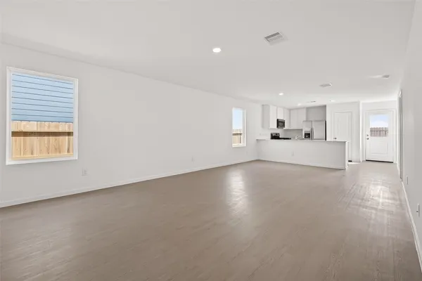 a view of a kitchen with refrigerator and windows