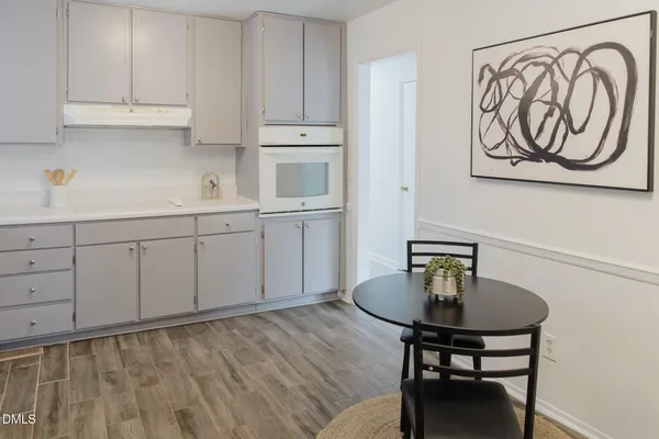 a kitchen with white cabinets and sink