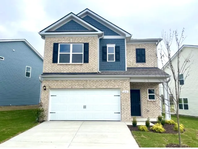 a front view of a house with a yard and garage