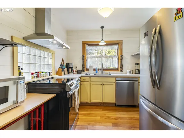 a kitchen with stainless steel appliances granite countertop a sink a stove a refrigerator and island