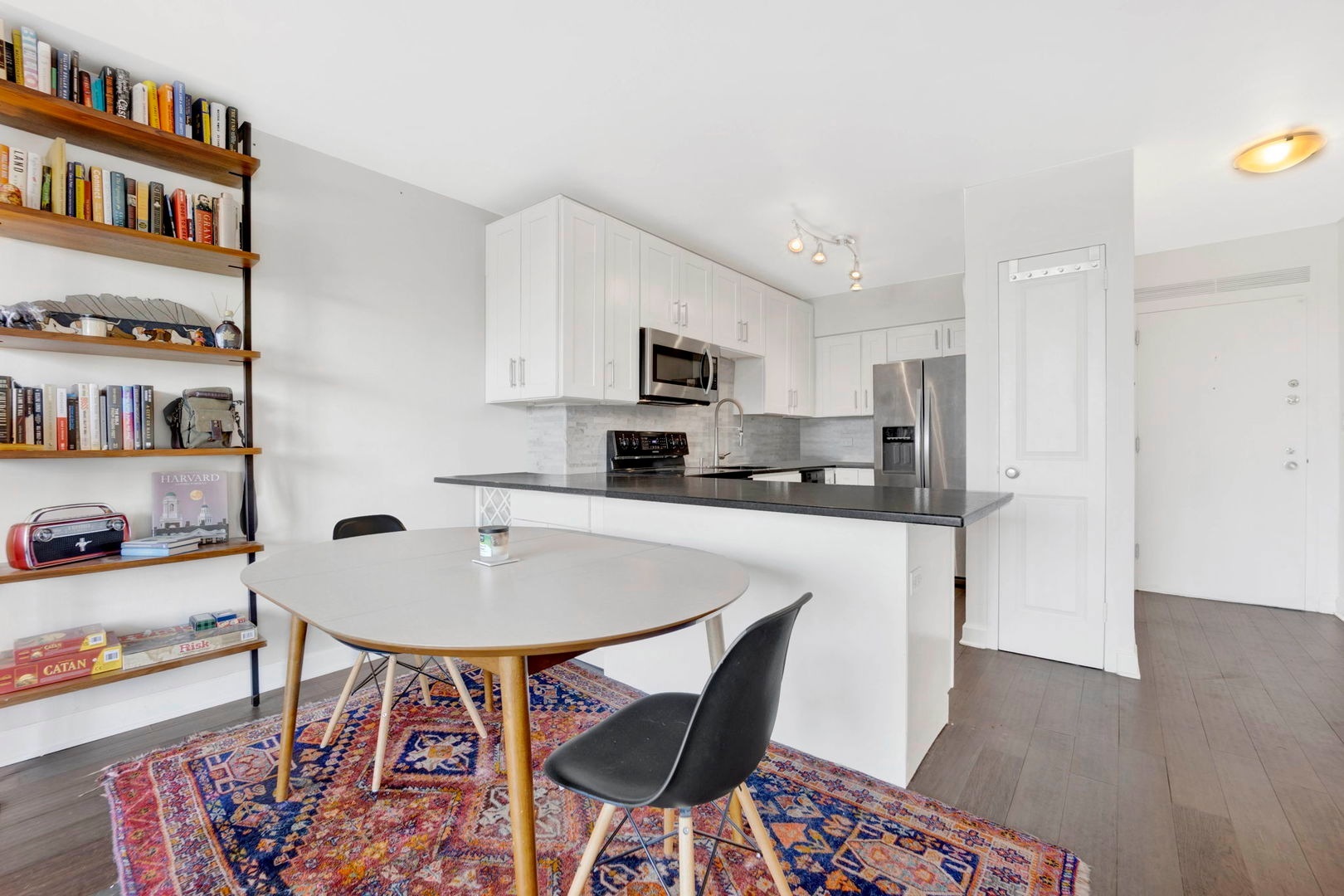 1550 North Lake Shore Drive, Unit 3C Chicago, IL 60610 - Photo 5 of 16 a kitchen with stainless steel appliances a dining table chairs and a refrigerator
