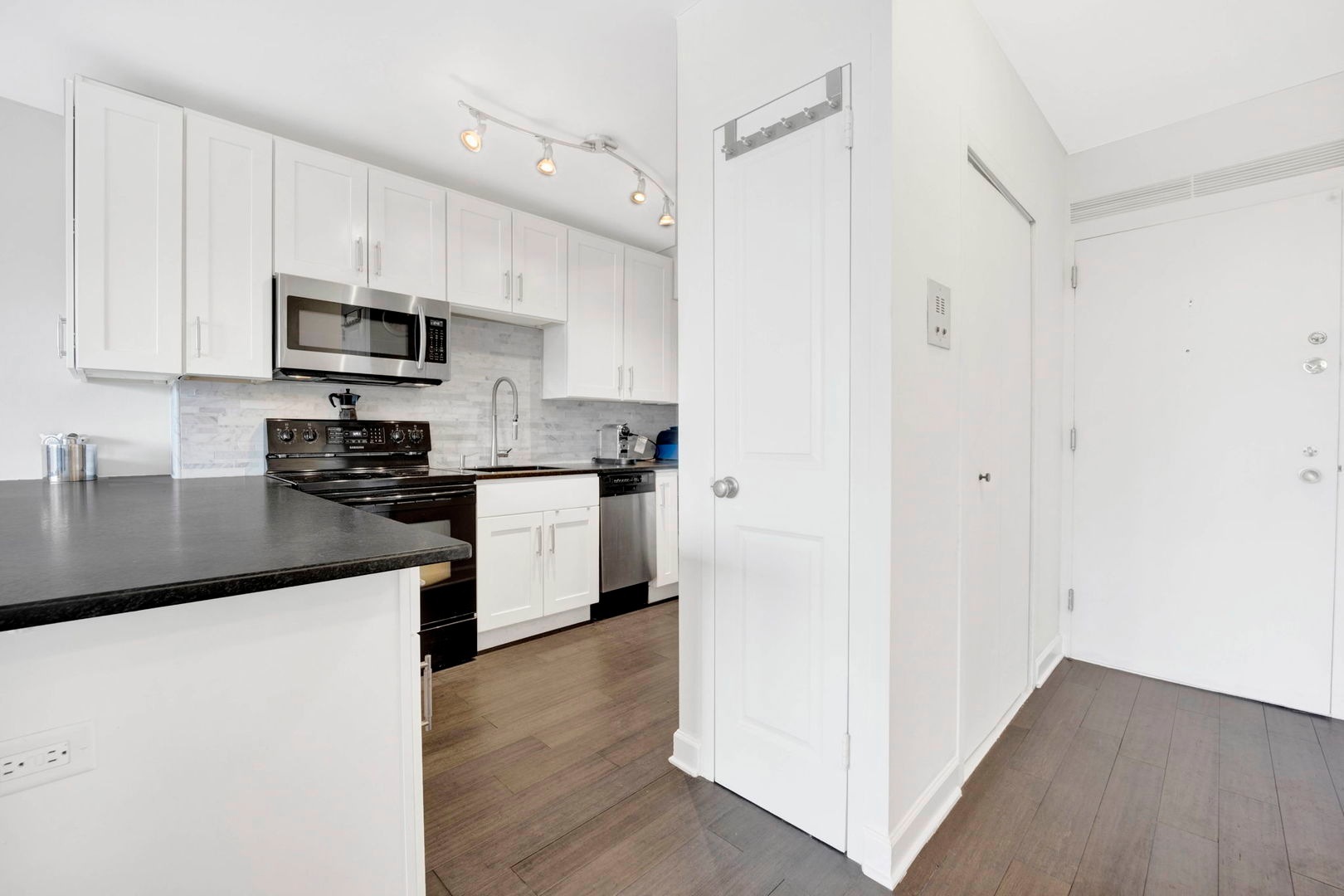 1550 North Lake Shore Drive, Unit 3C Chicago, IL 60610 - Photo 6 of 16 a kitchen with stainless steel appliances a refrigerator sink and white cabinets