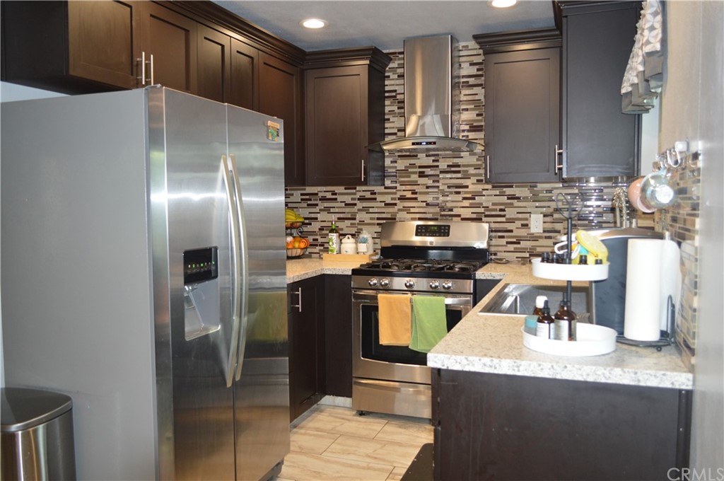 5577 Pioneer Boulevard, Unit 9 Whittier, CA 90601 - Photo 13 of 45 a kitchen with granite countertop a refrigerator and a stove