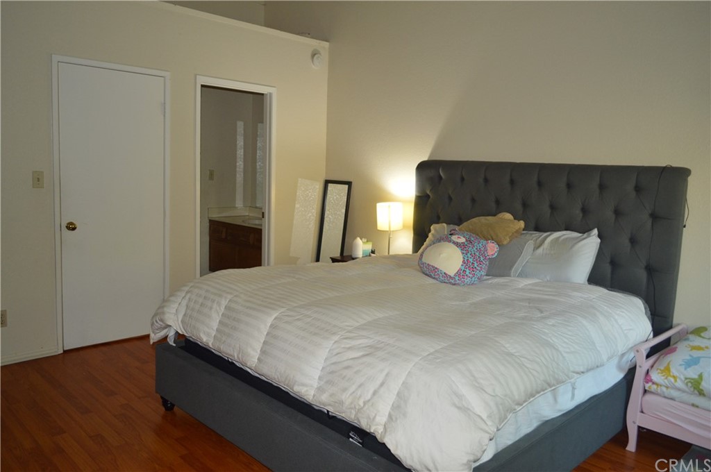 5577 Pioneer Boulevard, Unit 9 Whittier, CA 90601 - Photo 20 of 45 a large bed sitting in a bedroom and wooden floor
