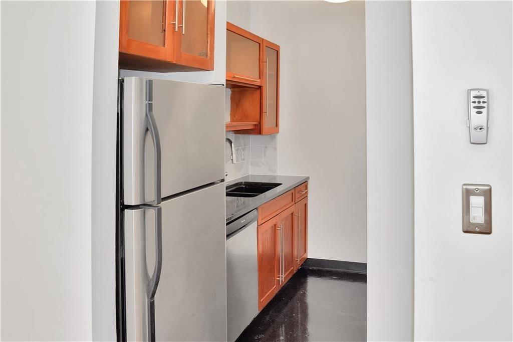 120 Ralph McGill Boulevard Northeast, Unit 402 Atlanta, GA 30308 - Photo 12 of 38 a white refrigerator freezer and a stove sitting inside of a kitchen