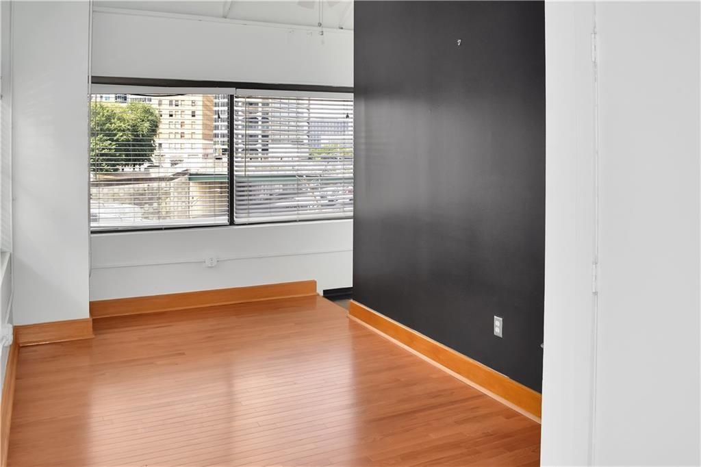 120 Ralph McGill Boulevard Northeast, Unit 402 Atlanta, GA 30308 - Photo 19 of 38 a view of empty room with wooden floor and fan