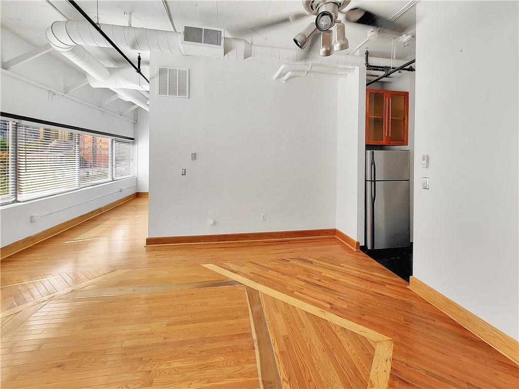 120 Ralph McGill Boulevard Northeast, Unit 402 Atlanta, GA 30308 - Photo 8 of 38 a view of empty room with a ceiling fan and wooden floor