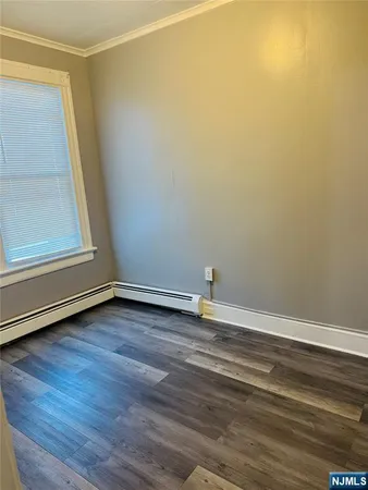 a view of a room with wooden floor and entrance