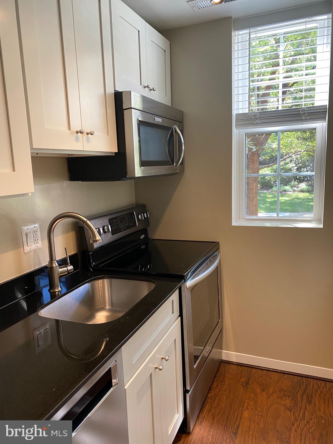 1805 Key Boulevard, Unit 511 Arlington, VA 22201 - Photo 8 of 26 a kitchen with granite countertop a sink a stove and cabinets