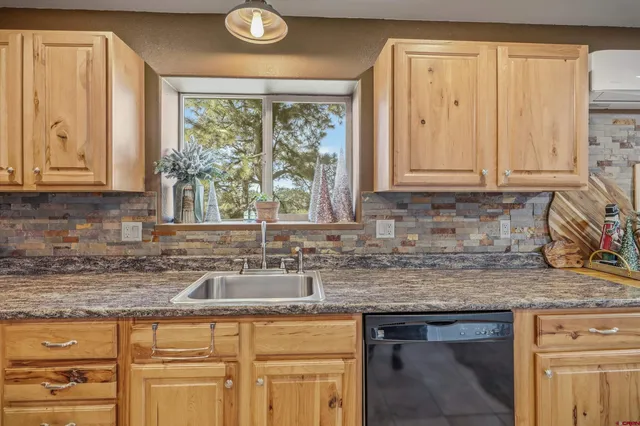 a kitchen with granite countertop a refrigerator and a stove top oven