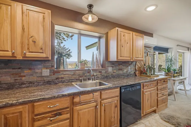 a kitchen with kitchen island granite countertop a sink a stove top oven and cabinets