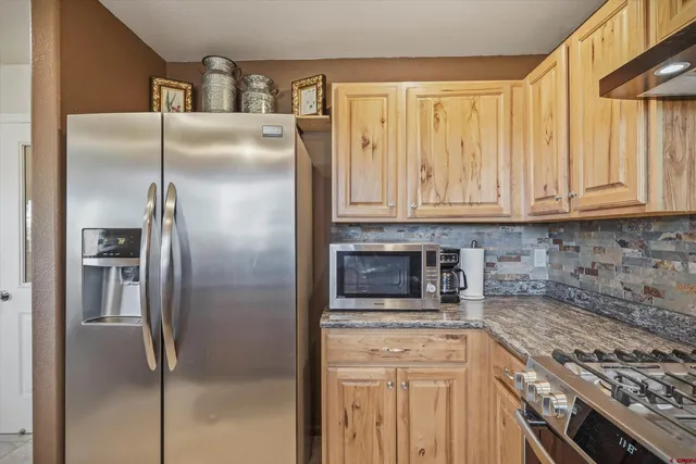 a kitchen with granite countertop a stove a sink and a granite counter tops