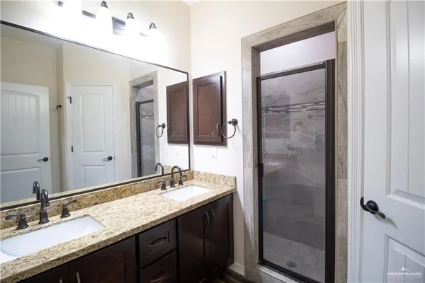 a bathroom with a granite countertop sink and a mirror