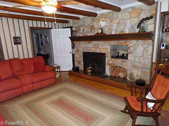 3161 Alamance Church Road Julian, NC 27283 - Photo 4 of 16 Den/Family/Great Room. Beautiful stone fireplace in the family room with exposed beams from trees on the property.