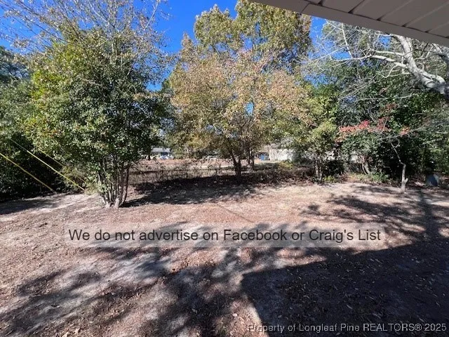 a view of dirt yard with a large tree
