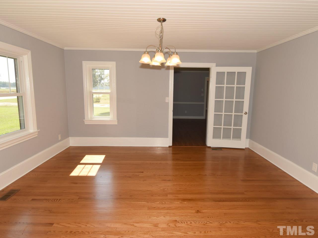 1525 Micro Road Selma, NC 27576 - Photo 21 of 25 Original glass doors open to the dining room with new easy care floors, beadboard ceilings, fresh paint, new lighting