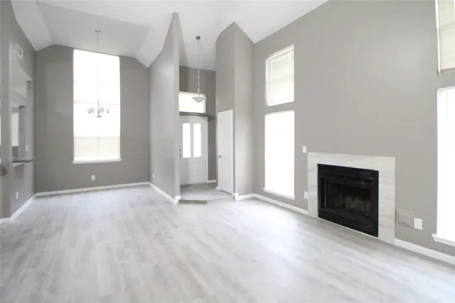 an empty room with windows and fireplace