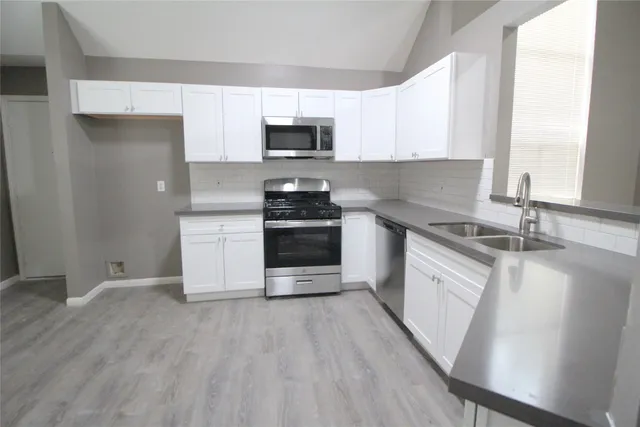 a kitchen with stainless steel appliances granite countertop a stove a sink and a microwave