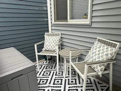 a balcony with table and chairs with wooden floor