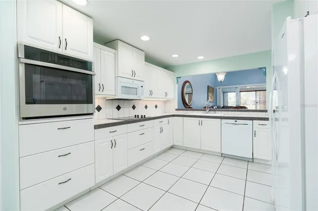 a kitchen with white cabinets appliances and sink