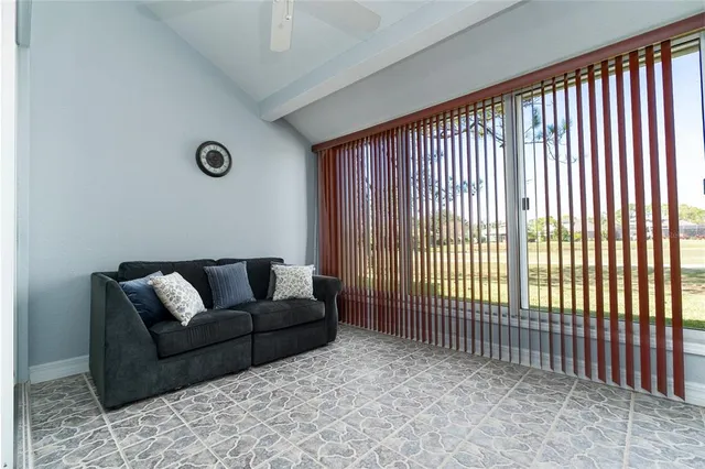 a living room with furniture and a floor to ceiling window