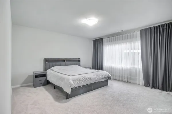 a spacious bedroom with a bed and a window