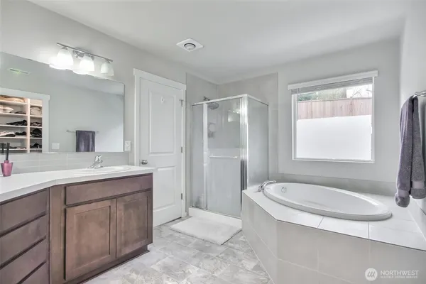 a bathroom with a tub sink and mirror