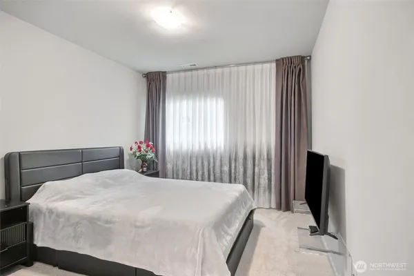 a bedroom with a large bed and a potted plant