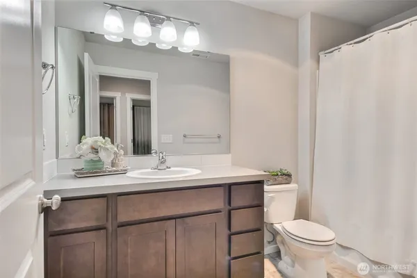 a bathroom with a toilet a sink and a large mirror
