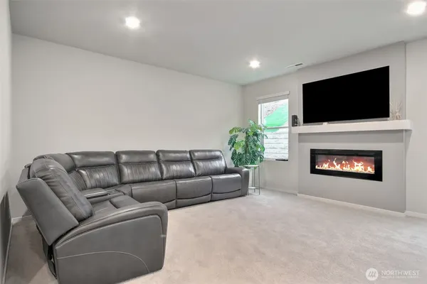 a living room with furniture a flat screen tv and a fireplace