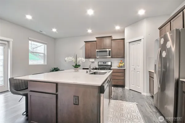 a kitchen with kitchen island a sink appliances and cabinets