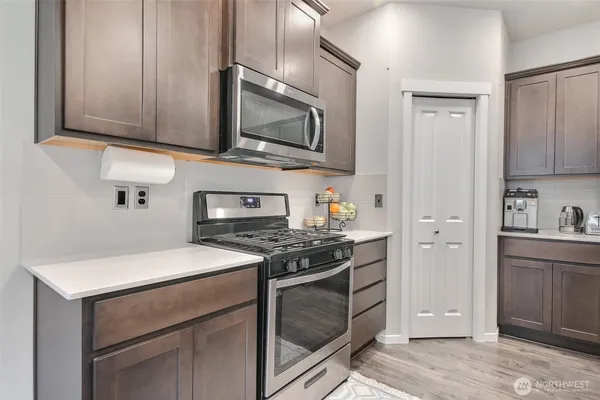 a kitchen with stainless steel appliances granite countertop white cabinets sink and stove top oven