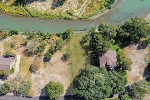an aerial view of a house with a yard and lake view