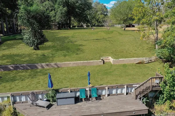 a view of a lake with a yard and large trees