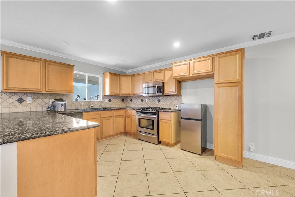 6220 Filkins Avenue Rancho Cucamonga, CA 91737 - Photo 14 of 37 a kitchen with stainless steel appliances granite countertop a sink stove and refrigerator