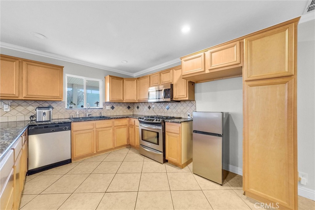 6220 Filkins Avenue Rancho Cucamonga, CA 91737 - Photo 15 of 37 a kitchen with stainless steel appliances granite countertop a refrigerator and a stove top oven