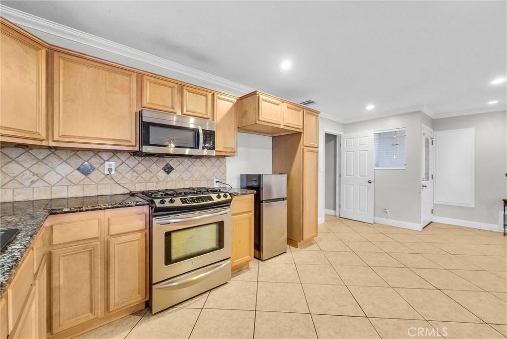 6220 Filkins Avenue Rancho Cucamonga, CA 91737 - Photo 16 of 37 a kitchen with stainless steel appliances granite countertop a stove a sink and a microwave