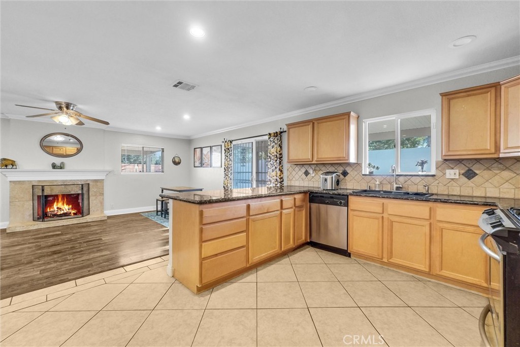 6220 Filkins Avenue Rancho Cucamonga, CA 91737 - Photo 17 of 37 a large kitchen with granite countertop a stove a sink and a window