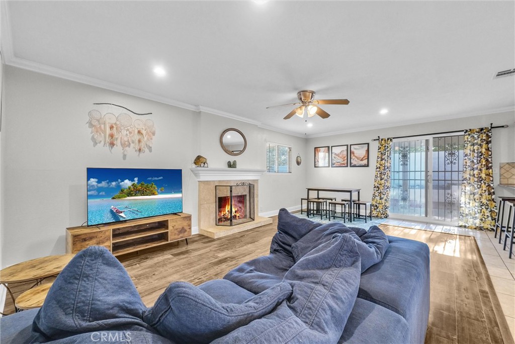 6220 Filkins Avenue Rancho Cucamonga, CA 91737 - Photo 8 of 37 a living room with furniture a flat screen tv and a fireplace