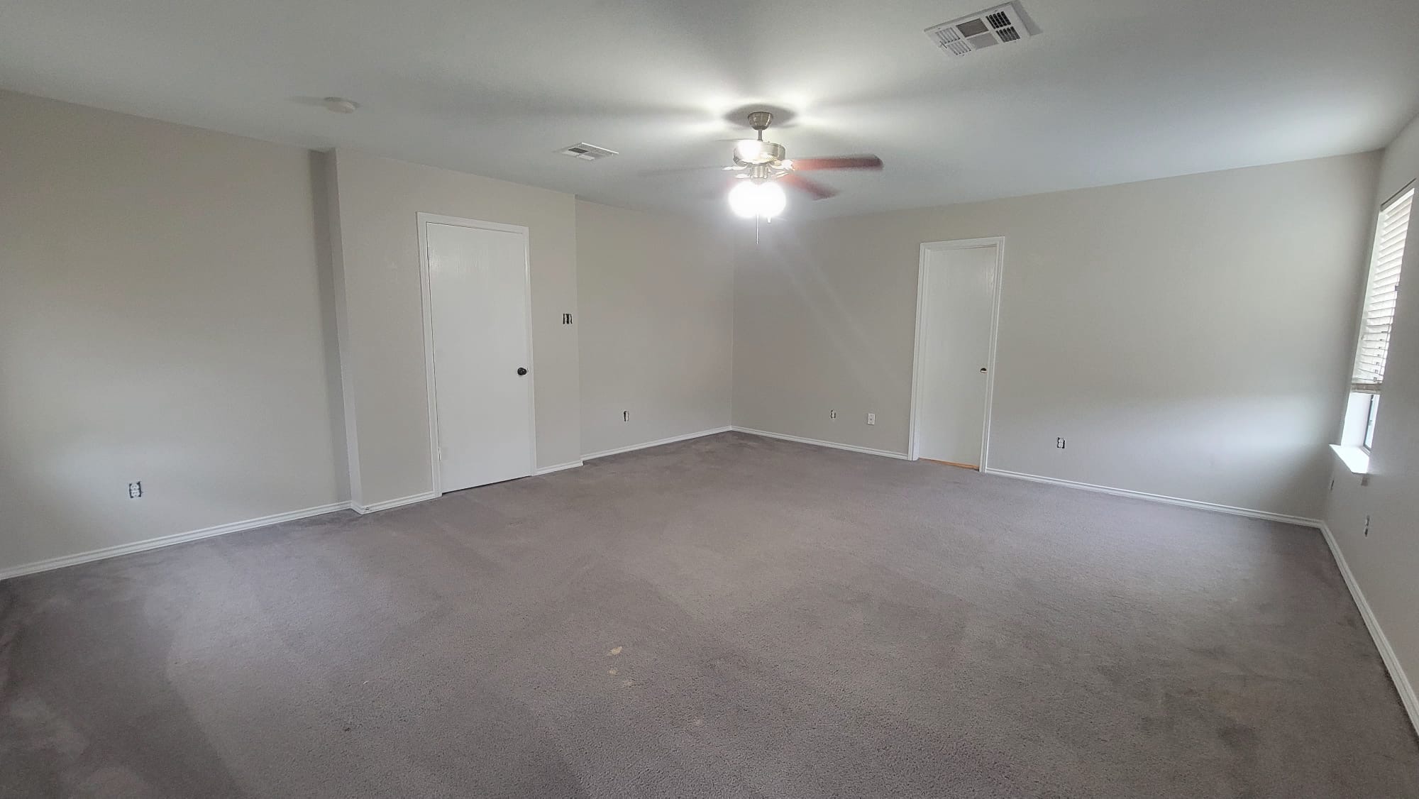 6829 Walkup Lane Austin, TX 78747 - Photo 10 of 18 A spacious, naturally illuminated room features soft carpeting, high ceilings, and a ceiling fan.