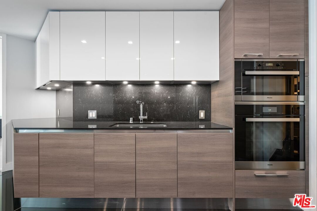 10490 Wilshire Boulevard, Unit 1004 Los Angeles, CA 90024 - Photo 18 of 45 a kitchen with granite countertop a stove and a sink with granite countertops
